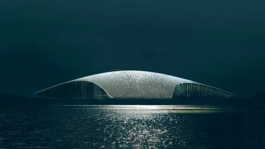 Low futuristic dome-shaped building spans calm water at night, with shimmering reflections beneath a dark sky.