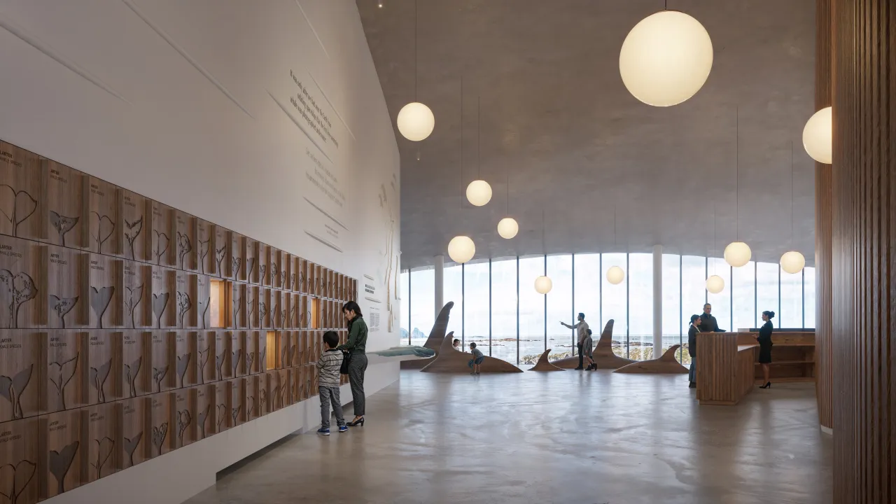 Spacious museum interior with wooden wall panels, hanging globe lights, visitors, and large windows.