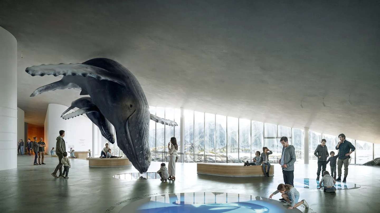 Large suspended whale sculpture in a bright, modern gallery with visitors, benches, and panoramic mountain view windows.