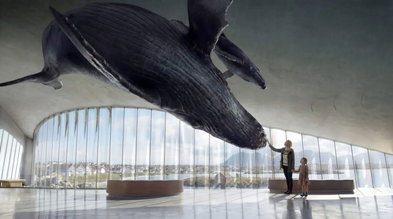 A huge whale sculpture hangs from a curved ceiling above a bright glass-walled hall overlooking water and mountains.